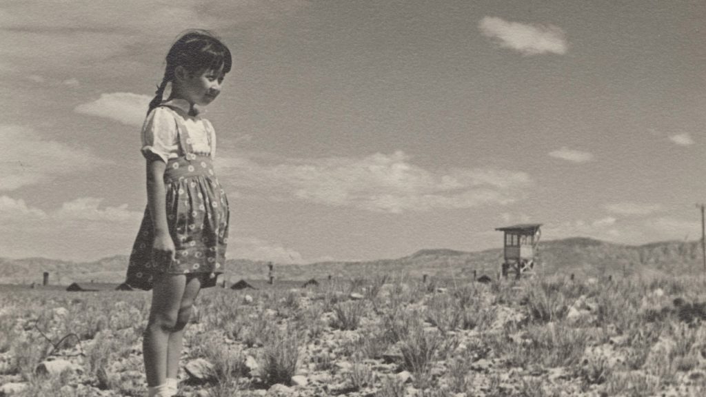 Young Heart Mountain incarceration girl with guard tower in the background